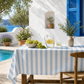Nappe rayée bleu et blanc imperméable en coton peigné sur une table de jardin méditerranéenne
